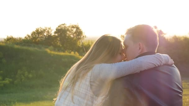 Visão traseira do jovem casal feliz sentado ao pôr do sol — Vídeo de Stock