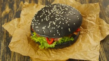 Ahşap masa üzerinde siyah burger