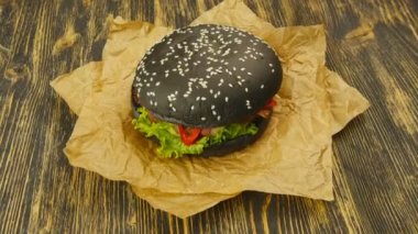 Ahşap masa üzerinde siyah burger