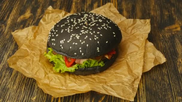 Burger noir sur table en bois — Video