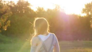 Hamile bir kadın günbatımında çimenlerin üzerinde çalışıyor