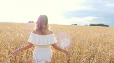Buğday alan üzerinde beyaz elbiseli güzel genç kadın