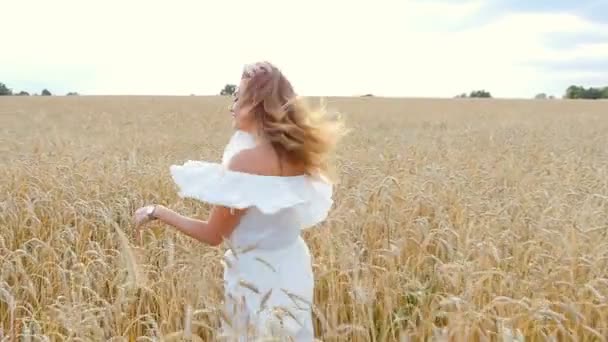 Mooie vrouw in een tarweveld weglopen — Stockvideo