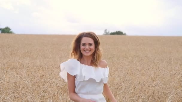 Ung flicka i vit klänning körs på fältet — Stockvideo