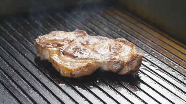 Chuleta de cerdo en una parrilla de sartén — Vídeos de Stock