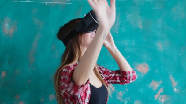 Молодая женщина играет в видеоигры с картонной гарнитурой виртуальной реальности — стоковое видео
