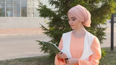 Belge kağıt ile duran Müslüman kadın