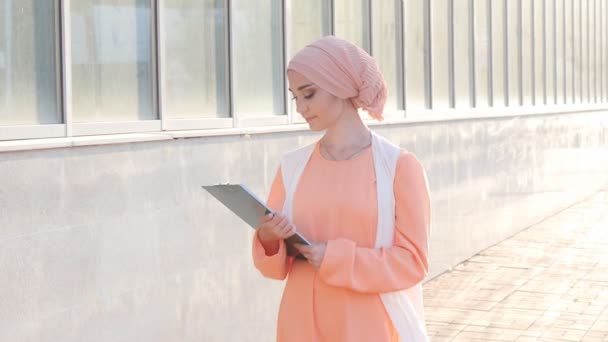 Moslimvrouw permanent met document papier — Stockvideo