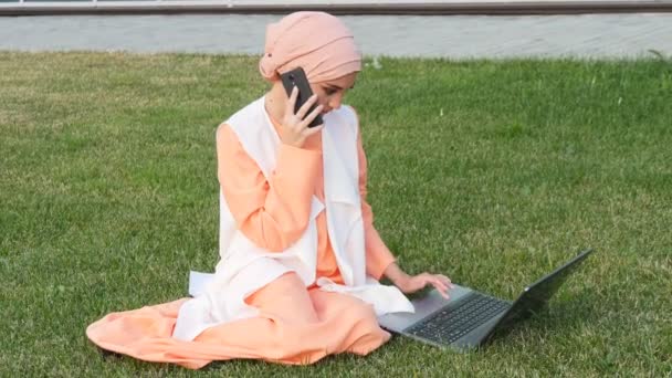 Mujer árabe de negocios en el teléfono móvil en un parque — Vídeos de Stock