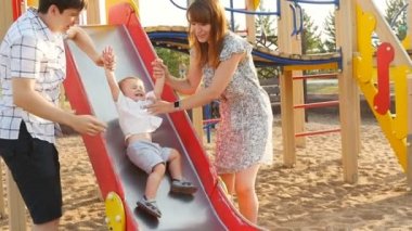 Family Riding On Roundabout In Park
