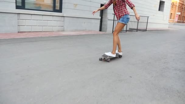 Mujer patinando al amanecer. Las piernas en el monopatín, se mueve hacia el éxito — Vídeo de stock