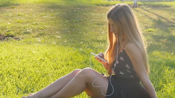 Young woman on grass with phone — Stock Video