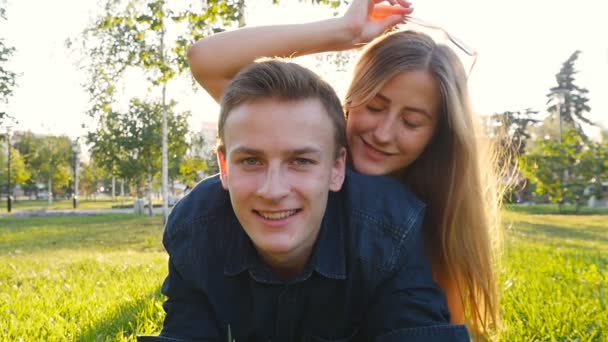 Pareja joven enamorada divirtiéndose y disfrutando en la hierba — Vídeo de stock