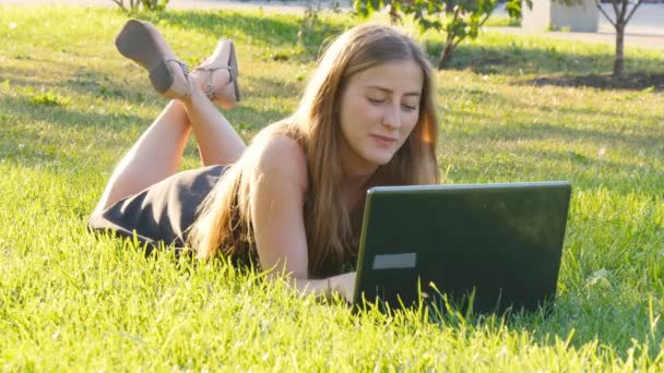 Femme sur ordinateur portable dehors sur l'herbe — Video