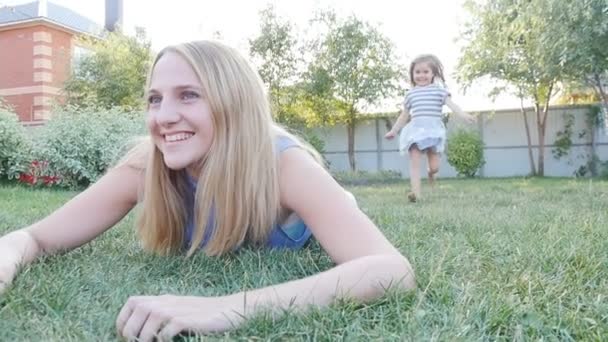 Feliz niña y su madre divirtiéndose al aire libre en la hierba verde — Vídeo de stock