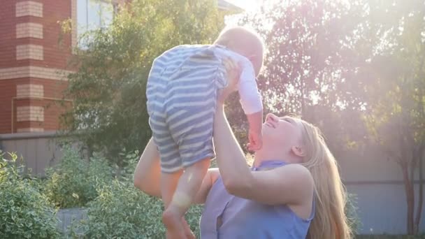 Silhouette d'une jeune mère et de son petit fils au coucher du soleil — Video