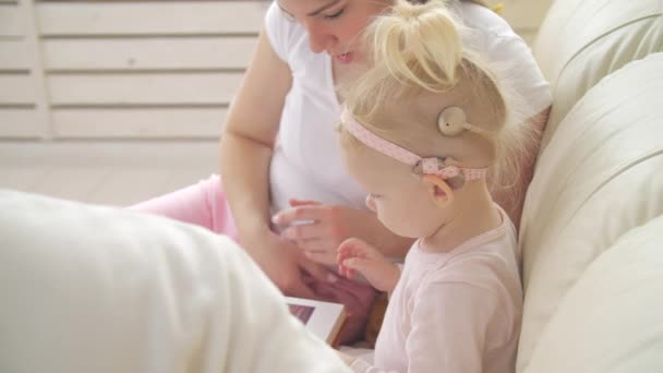 Conceito de deficiência auditiva e seu tratamento. Menina bonito com um implante coclear — Vídeo de Stock