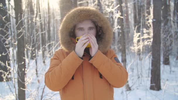 Turismo de invierno y concepto de senderismo. Barba hombre con bebida caliente en el bosque de invierno — Vídeos de Stock