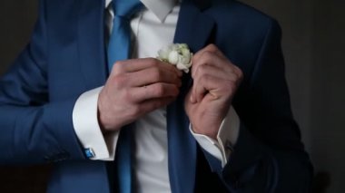 Bir kravat ve kol düğmeleri yaka çiçeği damat giyer