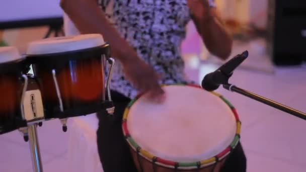 Joven percusionista masculino tocando tambores cubanos sobre fondo negro — Vídeo de stock