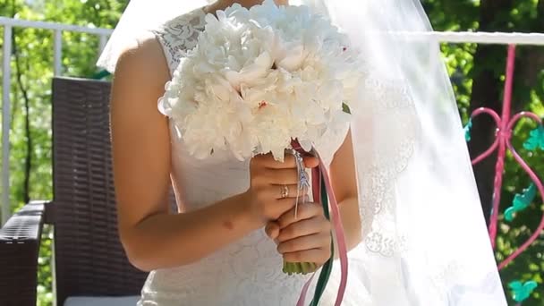 Bruidsboeket bloemen in handen van de bruid — Stockvideo