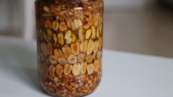 Honey with nuts In rotates in a glass jar — Stock Video