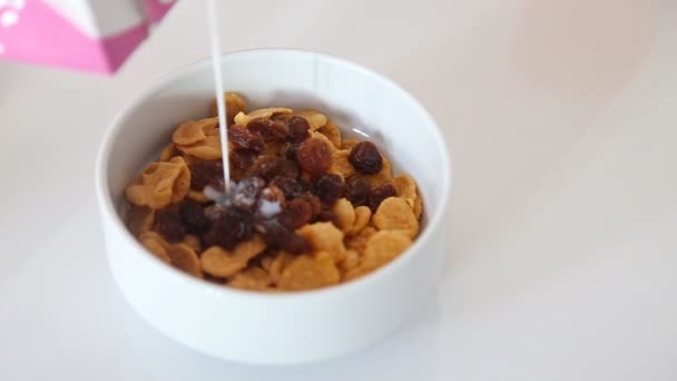 Milch in Schüssel mit Cornflakes gießen, Draufsicht — Stockvideo