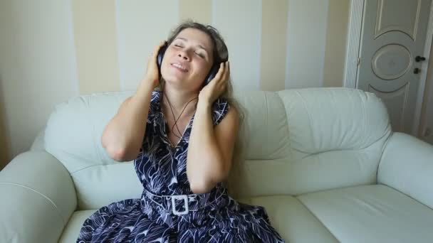 Young beautiful woman in bright outfit enjoying the music at home — Stock Video