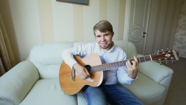 Practicando en tocar la guitarra. Guapos jóvenes tocando la guitarra — Vídeos de Stock