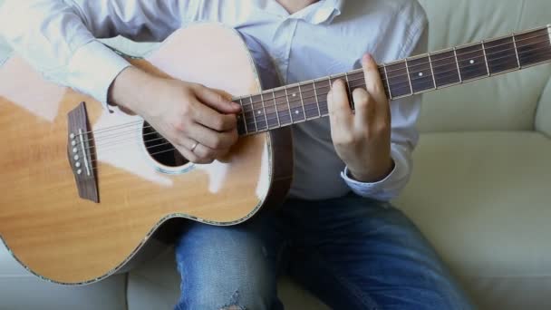 Practicando en tocar la guitarra. Guapos jóvenes tocando la guitarra — Vídeo de stock