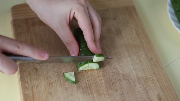 Hand cutting cucumber on cutting board with sharp knife — Stock Video