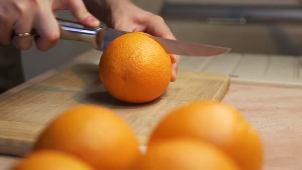 Mãos cortando laranja fresca na cozinha — Vídeo de Stock