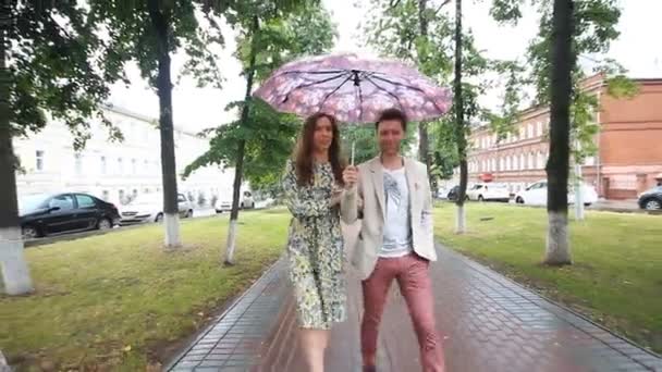 Belo casal andando sob guarda-chuva no parque — Vídeo de Stock