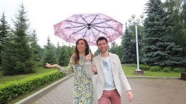 güzel çift park şemsiyesi altında yürüyüş