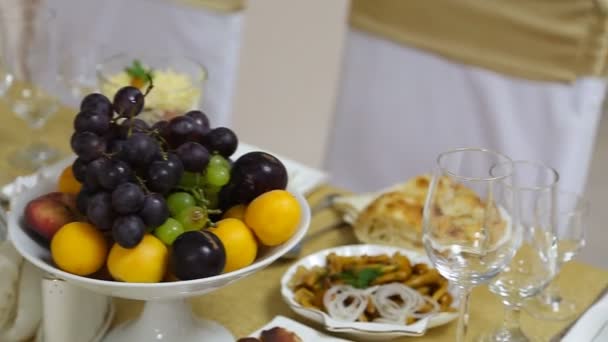 Servito per un tavolo da banchetto. Bicchieri di vino con tovaglioli, bicchieri e insalate. — Video Stock