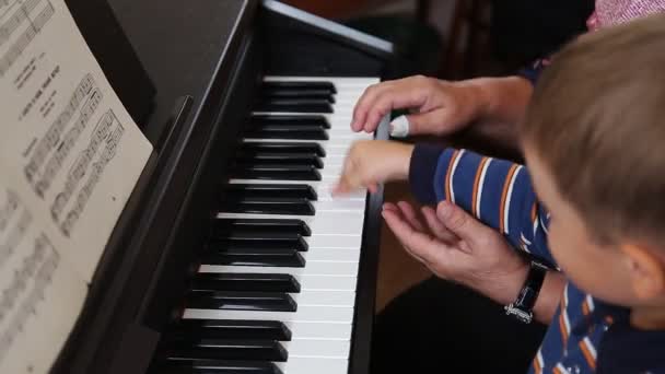 Pojke att lära sig hur man spelar piano — Stockvideo