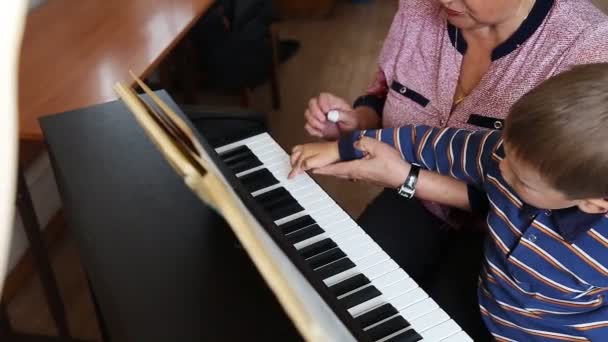 Pojke att lära sig hur man spelar piano — Stockvideo