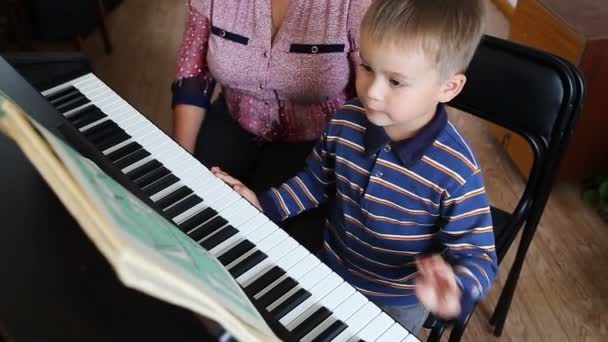 Pojke att lära sig hur man spelar piano — Stockvideo