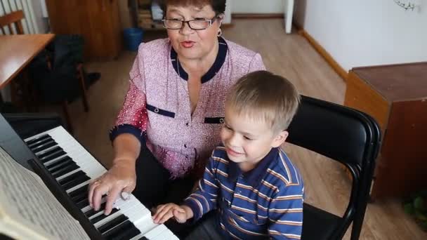 Fiú, tanulás, hogyan kell játszani zongorán — Stock videók