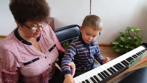 Pojke att lära sig hur man spelar piano — Stockvideo