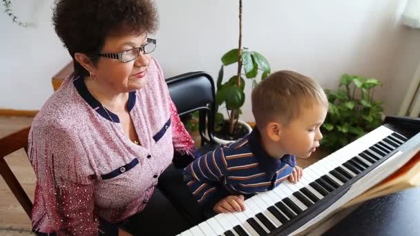 Pojke att lära sig hur man spelar piano — Stockvideo