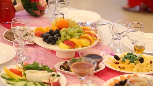 Servi pour une table de banquet. Verres à vin avec serviettes, verres et salades. — Video