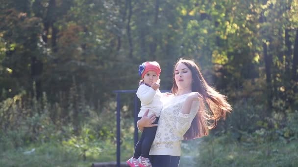 Moeder en baby dochter voor een wandeling in de herfst — Stockvideo