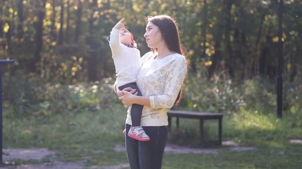 Mamá e hija bebé para un paseo en el otoño — Vídeo de stock