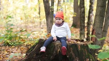 sonbahar akçaağaç yaprakları arasında neşeli gülümseyen küçük kız