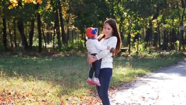 Mamá e hija bebé para un paseo en el otoño — Vídeos de Stock