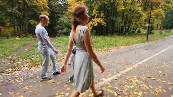 Feliz paseo familiar sonriente en el parque de otoño — Vídeo de stock