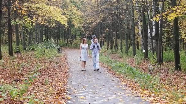 Feliz paseo familiar sonriente en el parque de otoño — Vídeo de stock