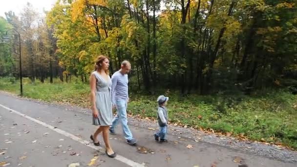 Glada leende familj gå i höst park — Stockvideo