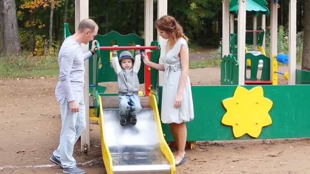 Papa maman et enfant jouant sur aire de jeux — Video